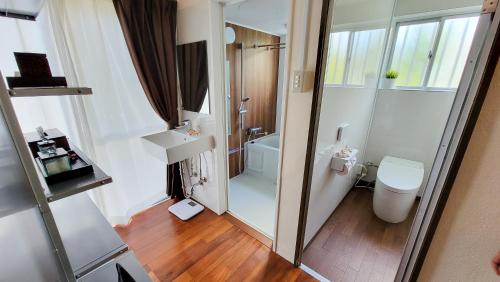 een kleine badkamer met een douche en een toilet bij Océanos - Sunset, BBQ, Beach & Kayak - オケアノス in Ishigaki Island