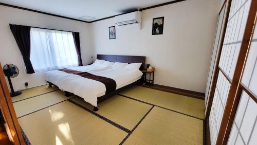 a bedroom with a bed and a large window at Océanos - Sunset, BBQ, Beach & Kayak - オケアノス in Ishigaki Island