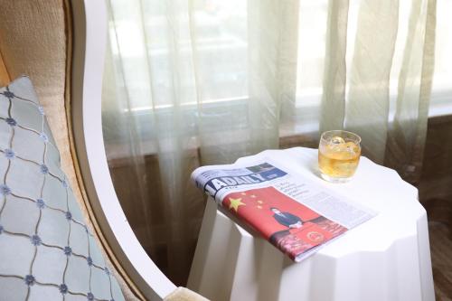 a table with a book and a glass on it at Shenzhen Baolilai International Hotel (Baoan, Fuyong) in Bao'an