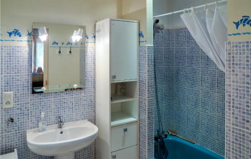 Pailloles的住宿－Lovely Home In Pailloles With Kitchenette，蓝色瓷砖浴室设有水槽和淋浴