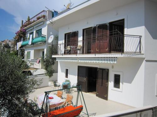 a white building with a balcony and a boat in front of it at Holiday Home Mona in Igrane
