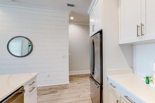 a kitchen with white cabinets and a stainless steel refrigerator at Lost Dunes #B in Gulf Shores