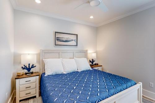 a bedroom with a blue bed and two night stands at Lost Dunes #B in Gulf Shores