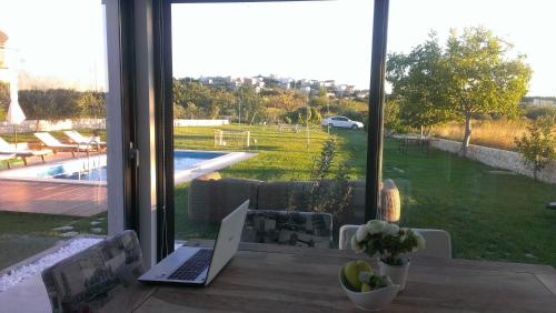 a laptop computer sitting on a table in front of a window at Luxury Villa Luminosa in Split