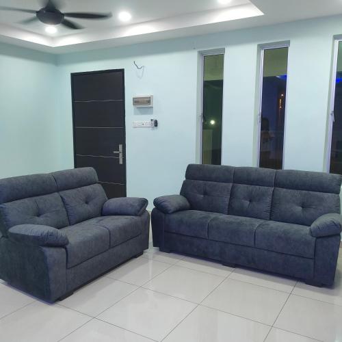 a living room with two couches and a ceiling fan at HAPPY STAY MOTEL in Jitra