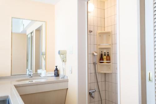 uma casa de banho com um lavatório e um espelho em Hotel Bell Harmony Ishigaki Island em Ishigaki