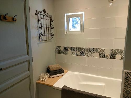 a bathroom with a white tub and a window at La Grange in Delettes