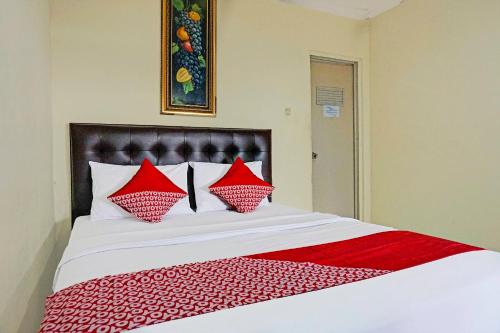 - une chambre avec un grand lit et des oreillers rouges dans l'établissement Cunang Hill Hotel & Resort, à Bogor