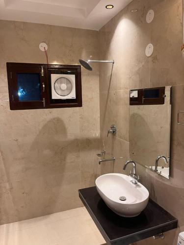 a bathroom with a white sink and a shower at The Divine Oak Golden Leaf in Katra