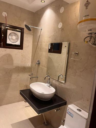 a bathroom with a sink and a mirror at The Divine Oak Golden Leaf in Katra