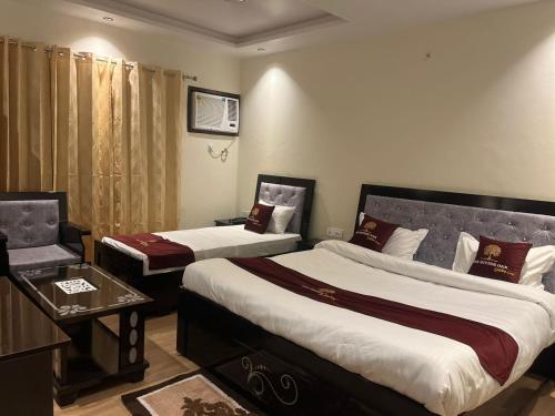 a hotel room with two beds and a table at The Divine Oak Golden Leaf in Katra