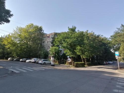 an empty street with a building and cars parked at Bethlen Apartman in Odorheiu Secuiesc
