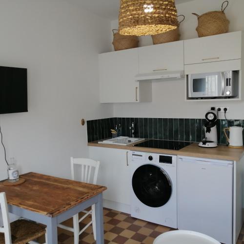 une cuisine avec une machine à laver et une table dans l'établissement A côté de la mer, à Ault