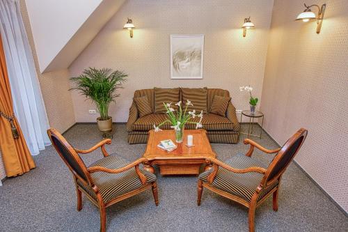 a living room with a couch and a table and chairs at White Lily Apartment in Klaipėda