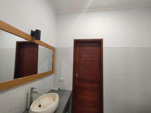 un baño con lavabo y espejo en Coco Blu Villa, en Singaraja
