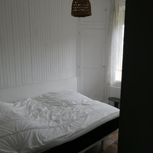 - un lit blanc dans une chambre avec fenêtre dans l'établissement A côté de la mer, à Ault