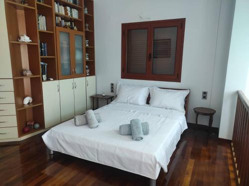 um quarto com uma cama branca com duas almofadas em Niforeika panorama em Kato Achaia