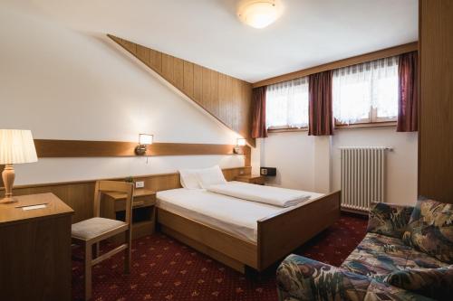 Кровать или кровати в номере Laguscei Dolomites Mountain Hotel