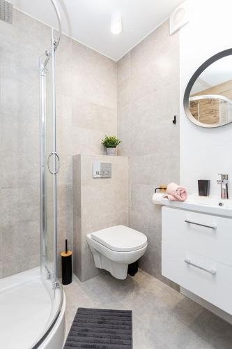 a bathroom with a toilet and a sink and a shower at Rybacka 48 - Twoje miejsce wypoczynku, domki, studia, apartamenty, rowery, hulajnogi in Jantar