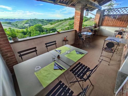 a table and chairs on a balcony with a view at La Tomatica In Commedia in Mongardino