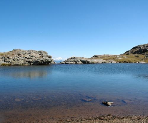 a large body of water with some rocks in it at Ferienwohnungen Appartementhaus Hohe Tauern in Obervellach
