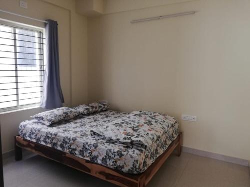 een slaapkamer met een bed in een kamer met een raam bij Castle JP Deluxe in Bangalore
