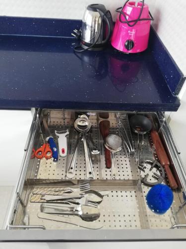 a drawer filled with dishes and utensils at JP Deluxe in Bengaluru