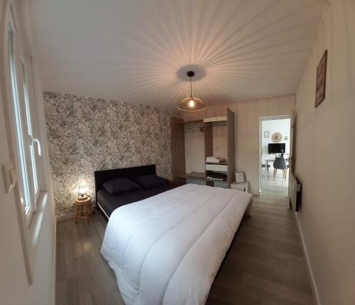 1 dormitorio con 1 cama blanca grande en una habitación en Maison Mon p’tit bonheur, en Changey