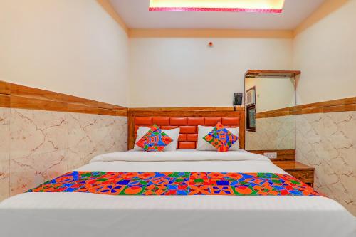 um quarto com uma cama grande e um edredão colorido em FabExpress Shree Galaxy em Kanpur