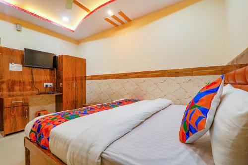 a bedroom with a bed with a tv on the wall at FabHotel Shree Galaxy in Kānpur