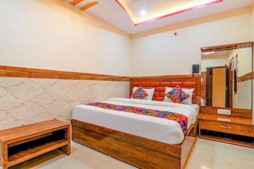 1 dormitorio con 1 cama grande y espejo en FabExpress Shree Galaxy, en Kānpur