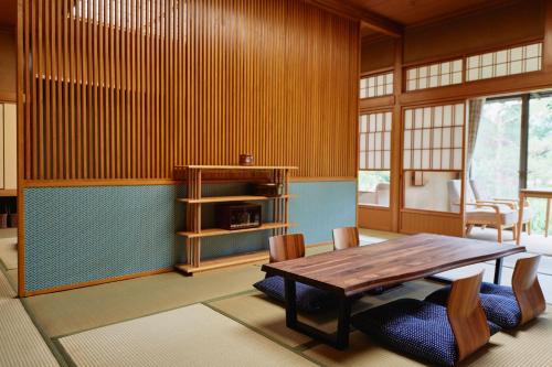 jadalnia z drewnianym stołem i krzesłami w obiekcie Takamiya Ryokan Sagiya Sansorai w mieście Kaminoyama