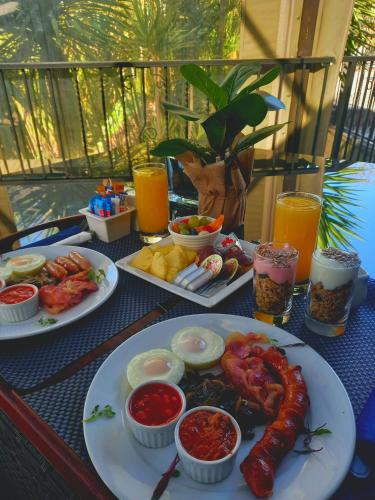 a table with two plates of food and drinks at Waterfalls Boutique Hotel in Pretoria