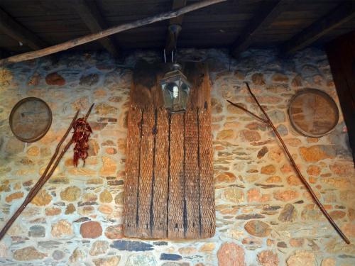 a clock on the side of a stone wall at O Palleiro do Pe do Forno in Orellán