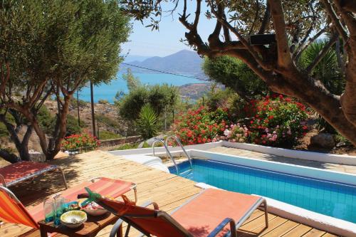 un patio avec une table et des chaises à côté d'une piscine dans l'établissement Beautiful Villa Helios with stunning sea view!, à Vrouchas