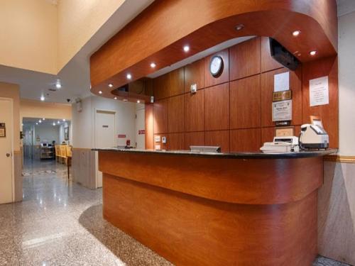 a lobby with a large wooden counter in a hospital at Flushing Hotel in Queens