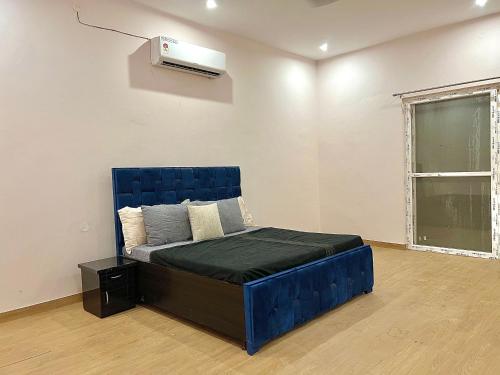 a bedroom with a blue bed and a air conditioner at entire farm and pool for holi party 3bhk with very big hall in Gurgaon