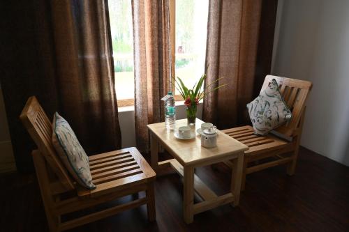 une table et deux chaises avec une table et une fenêtre dans l'établissement Hunder Haven, à Leh