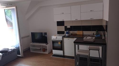 a small kitchen with a stove and a tv at Sleep and drive 2 in Sarajevo