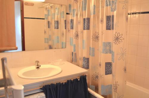ein Bad mit einem Waschbecken und einem Duschvorhang in der Unterkunft Granges 8 - BEL APPT 4P AU PIED DES PISTES DOMAINE ALPE D'HUEZ in Villard-Reculas