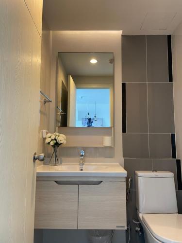 a bathroom with a sink and a toilet and a mirror at Breezy room with balcony view Sukhumvit77 in Bangkok