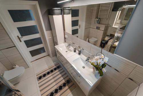 Un baño con lavabo, espejo e inodoro. en Kiton House, en Skarlin