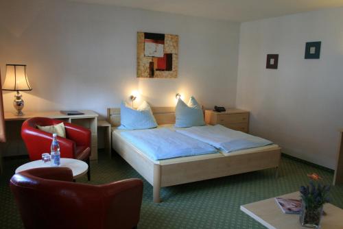 une chambre d'hôtel avec un lit, une table et des chaises dans l'établissement Altes Zollhaus, à Bad Tölz