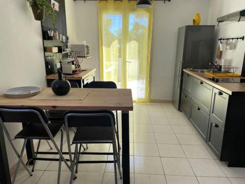 a kitchen with a wooden table and some chairs at Casa Azzura in Bastia