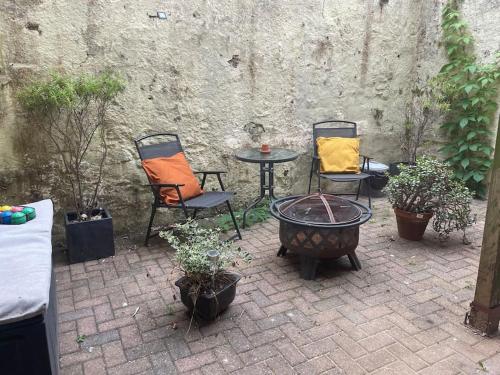 トーキーにあるGarden Flat Torquay Just 2 mins walk from the Harbourのパティオ(椅子2脚、植物テーブル付)