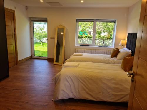 a bedroom with two beds and a window at Ard Kielin Apartment Luxury 2 bedroom in Killarney in Killarney