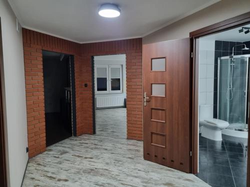 a hallway with a bathroom with a toilet and a door at Villa Akacjowa in Turbia