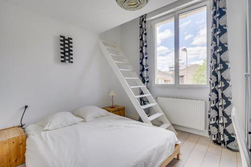 ein Schlafzimmer mit einem weißen Bett und einer Leiter neben einem Fenster in der Unterkunft Bordeaux centre, 5 chambres privées, piscine, parking in Bordeaux