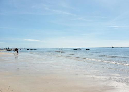 a group of people walking on the beach at Thipurai City Hotel in Hua Hin
