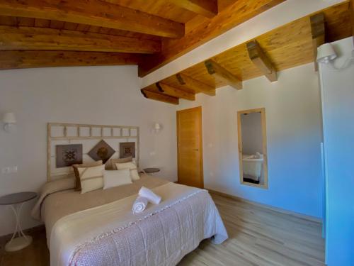 a bedroom with a large bed and wooden ceilings at Apartamentos La Ventana de Mogrovejo in Mogrovejo